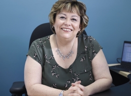 Photo of Agency Director of Operations Donna Charbonneau sitting at her desk 